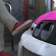A car only an inch away from touching a man's red shoe.